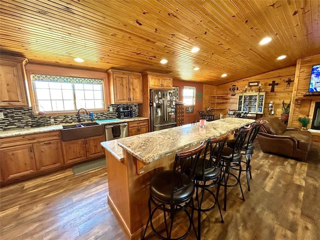 kitchen featuring dark wood finished floors, a sink, dishwasher, fridge with ice dispenser, and open floor plan