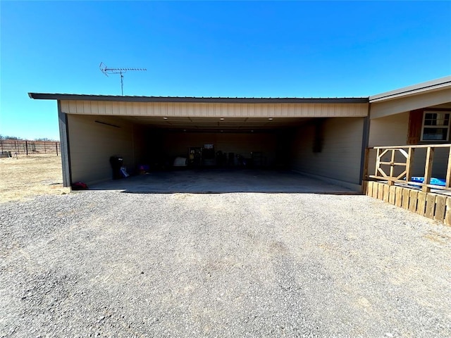 view of outbuilding with a carport and gravel driveway