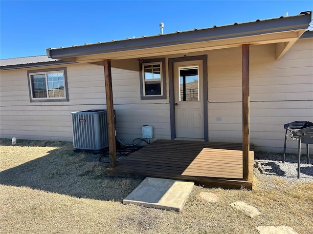 view of exterior entry with cooling unit and metal roof