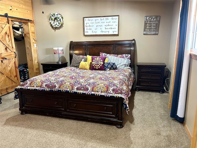 carpeted bedroom featuring a barn door