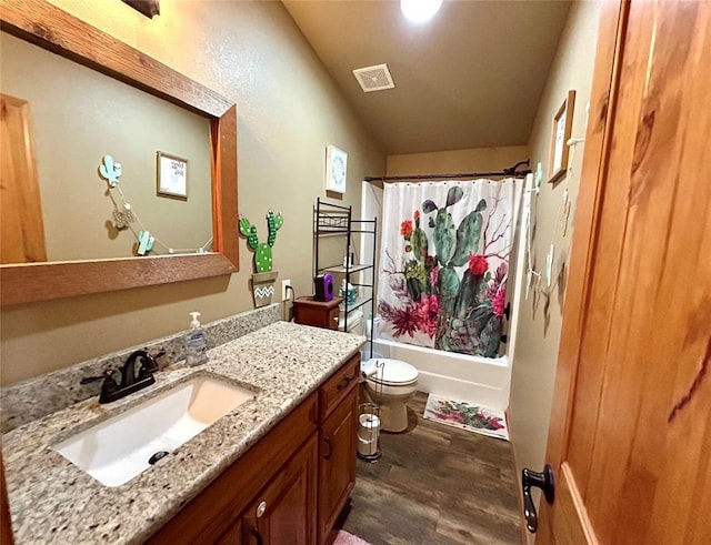 bathroom with visible vents, toilet, wood finished floors, shower / bath combination with curtain, and vanity