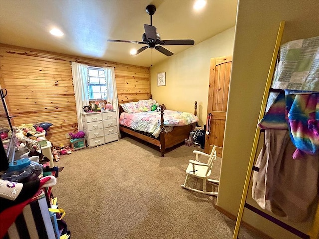 carpeted bedroom with wooden walls, recessed lighting, and ceiling fan