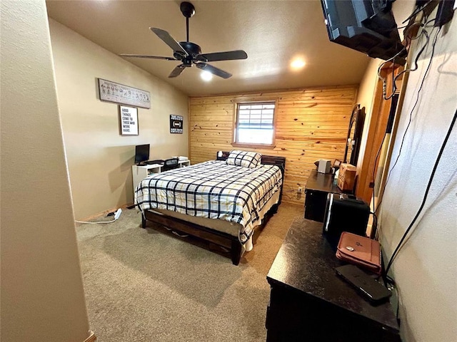 carpeted bedroom featuring ceiling fan, wood walls, and vaulted ceiling