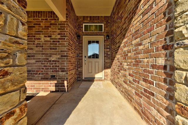 doorway to property featuring brick siding