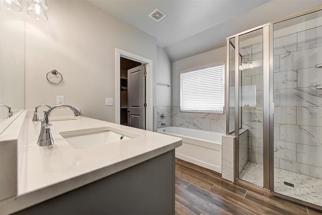 full bathroom featuring a sink, visible vents, wood finished floors, and a shower stall