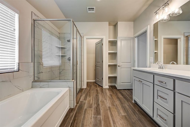 full bath with vanity, visible vents, wood tiled floor, a stall shower, and a garden tub