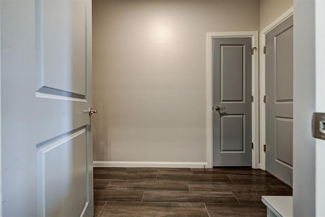 hallway featuring baseboards and wood tiled floor