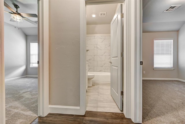 hallway featuring baseboards, visible vents, and carpet floors