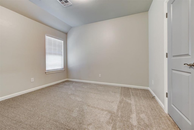 carpeted empty room featuring visible vents, baseboards, and vaulted ceiling