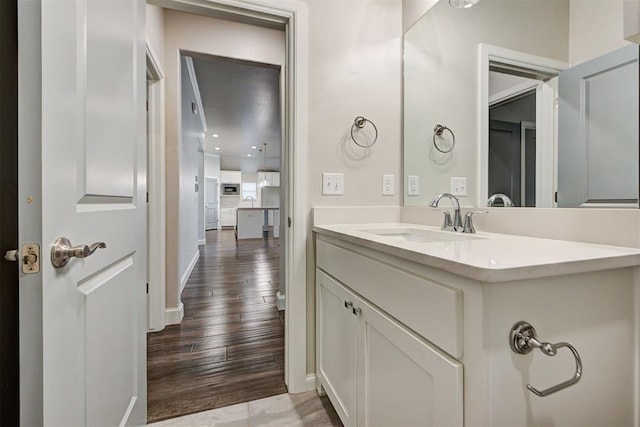 bathroom featuring baseboards, wood finished floors, and vanity