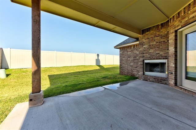 view of patio / terrace featuring fence and an outdoor brick fireplace