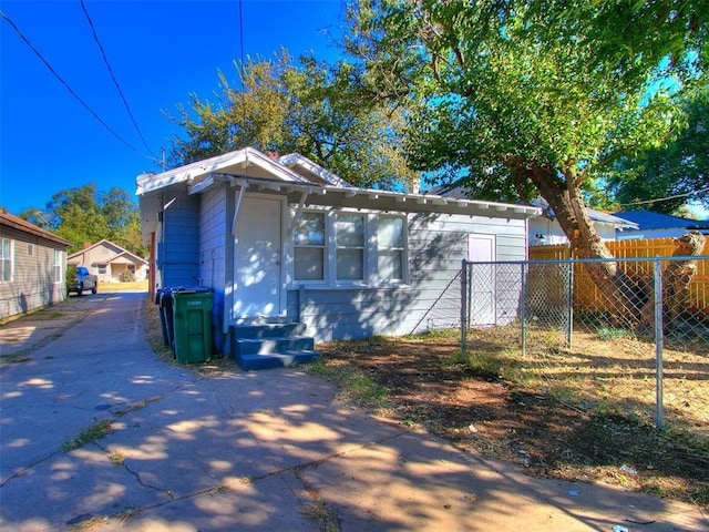 exterior space with concrete driveway and fence