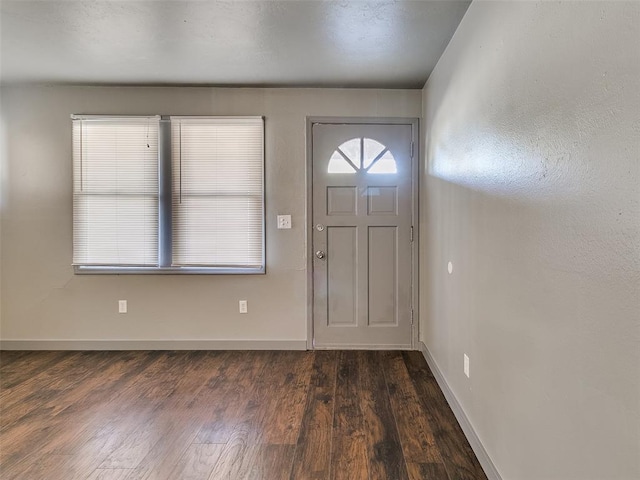 foyer featuring dark wood finished floors and baseboards