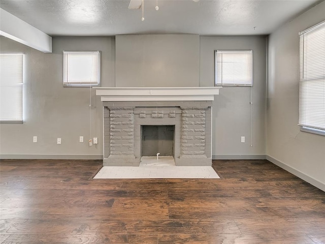 unfurnished living room featuring a fireplace with flush hearth, plenty of natural light, and wood finished floors