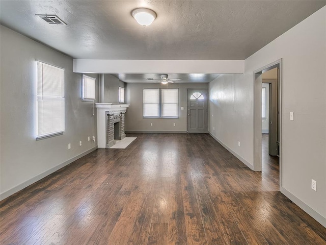 unfurnished living room featuring dark wood finished floors, a fireplace with flush hearth, baseboards, and a textured ceiling