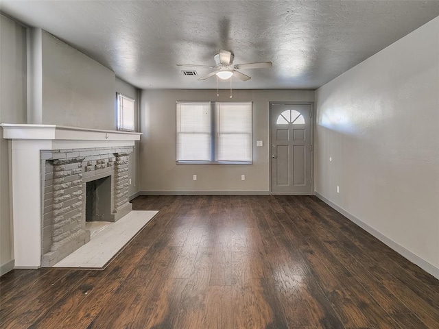 unfurnished living room featuring visible vents, baseboards, a fireplace, wood-type flooring, and a textured ceiling