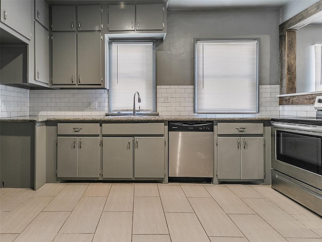 kitchen with a sink, gray cabinets, and stainless steel appliances