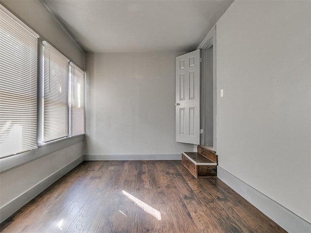 empty room with baseboards and wood finished floors