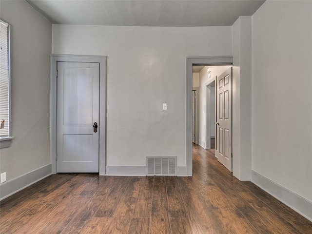 spare room with visible vents, baseboards, and wood finished floors