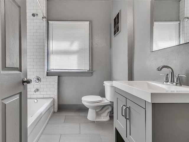 bathroom featuring vanity, baseboards, tile patterned flooring, toilet, and a bathtub