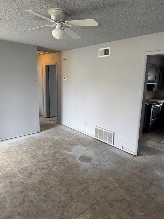 unfurnished room with a ceiling fan, visible vents, and a textured ceiling