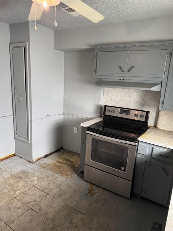 kitchen featuring under cabinet range hood, stainless steel electric stove, gray cabinets, and ceiling fan