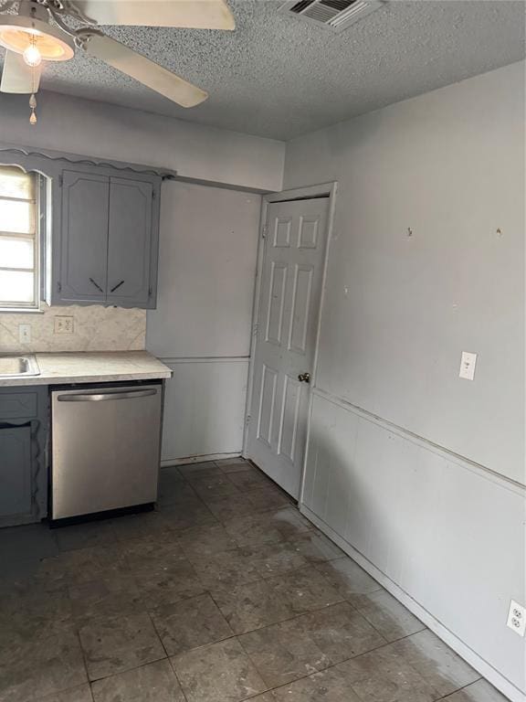 kitchen with dishwasher, light countertops, decorative backsplash, gray cabinets, and a textured ceiling