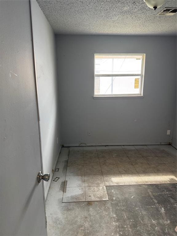 empty room with visible vents and a textured ceiling