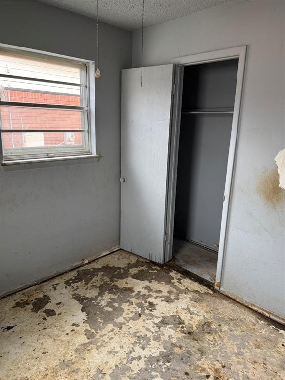 unfurnished bedroom with a closet and a textured ceiling