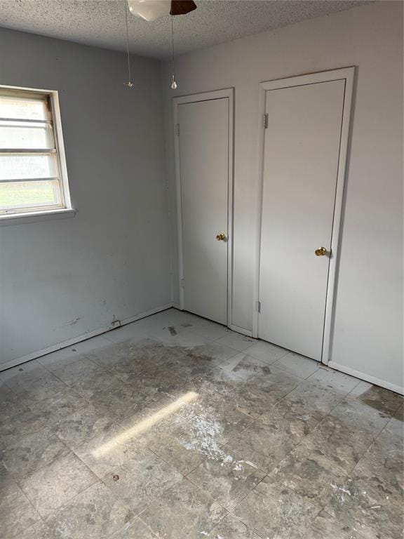 unfurnished bedroom with a textured ceiling and a ceiling fan