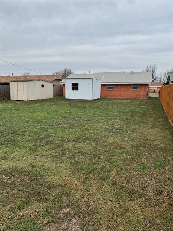 view of yard with a storage unit, a fenced backyard, and an outdoor structure