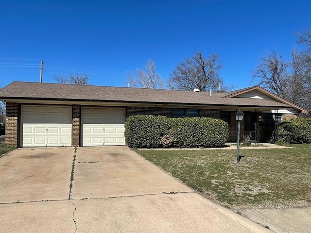 ranch-style home with a front yard, brick siding, concrete driveway, and an attached garage