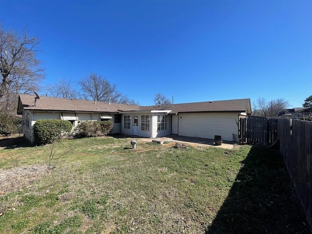 back of property with a yard and fence