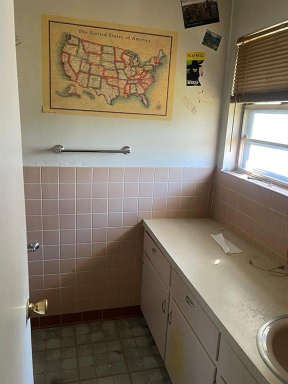 bathroom featuring vanity and tile walls