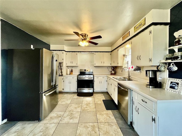 kitchen featuring light tile patterned floors, a sink, stainless steel appliances, light countertops, and white cabinets