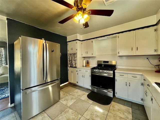 kitchen featuring appliances with stainless steel finishes, white cabinets, light countertops, light tile patterned floors, and ceiling fan