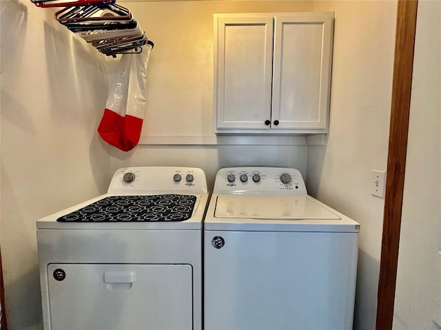 clothes washing area featuring cabinet space and washing machine and dryer