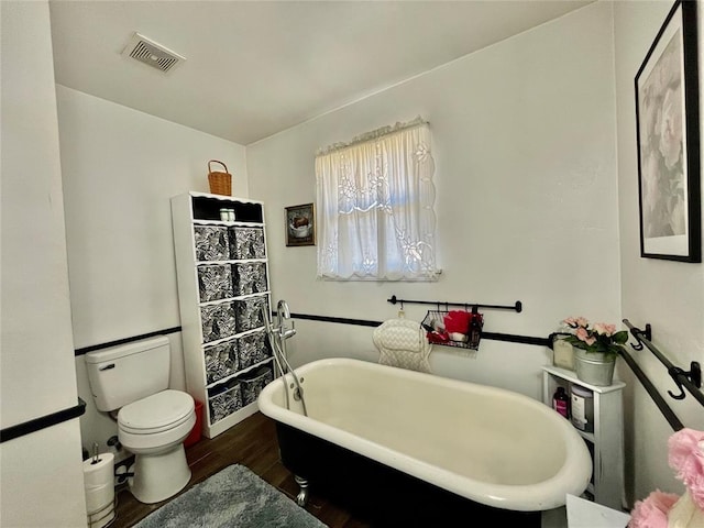 full bathroom featuring visible vents, toilet, wood finished floors, and a freestanding bath