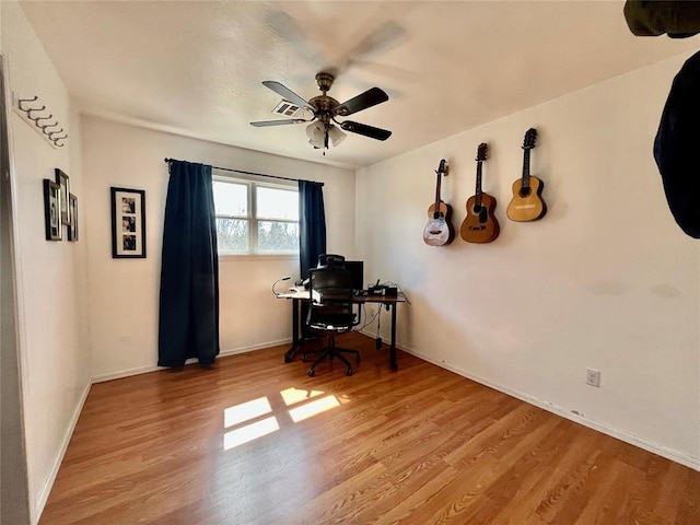 office featuring baseboards, a ceiling fan, and wood finished floors