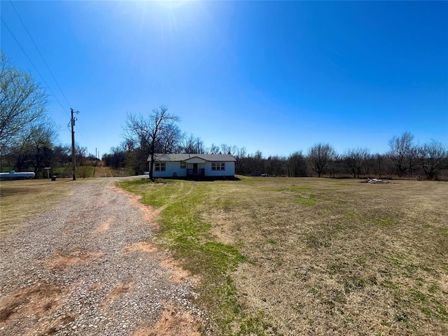 view of front of house featuring gravel driveway and a front lawn