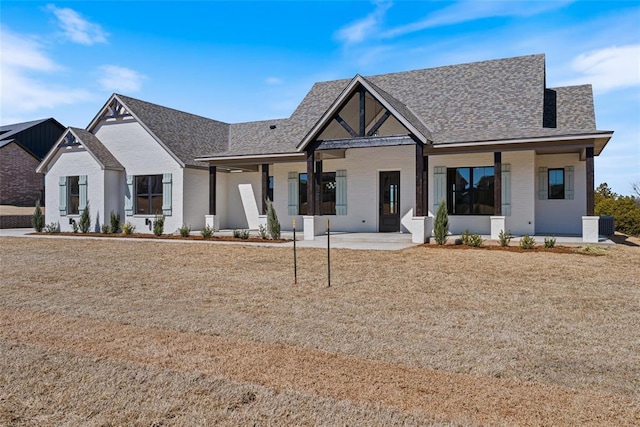 modern farmhouse style home featuring a front lawn and roof with shingles