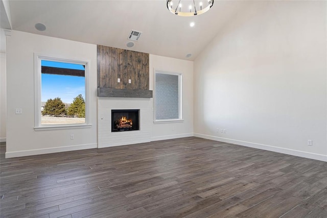 unfurnished living room featuring visible vents, a large fireplace, baseboards, dark wood finished floors, and vaulted ceiling