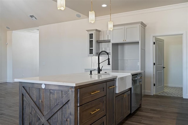 kitchen featuring visible vents, dark wood-style flooring, a sink, light countertops, and stainless steel dishwasher