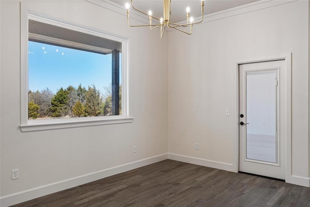 empty room featuring a chandelier, baseboards, and dark wood-style floors