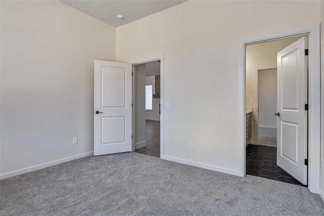 unfurnished bedroom with baseboards and dark colored carpet