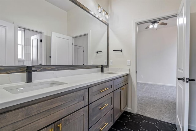 bathroom featuring tile patterned floors, double vanity, baseboards, and a sink