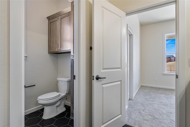 bathroom with tile patterned floors, toilet, and baseboards