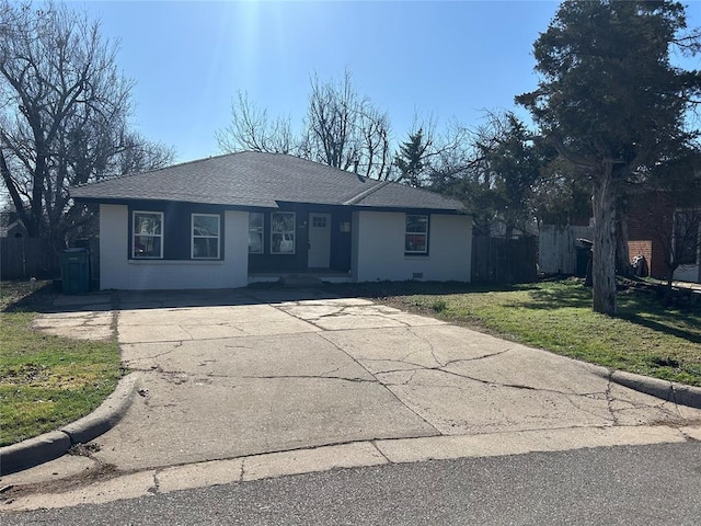 ranch-style home with a front yard, concrete driveway, fence, and a shingled roof