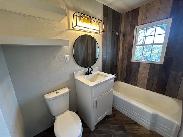 full bath with vanity, bathing tub / shower combination, toilet, and a textured wall