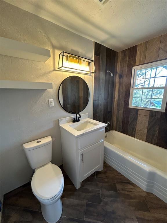 full bath featuring toilet, vanity, shower / bathing tub combination, a textured wall, and a textured ceiling